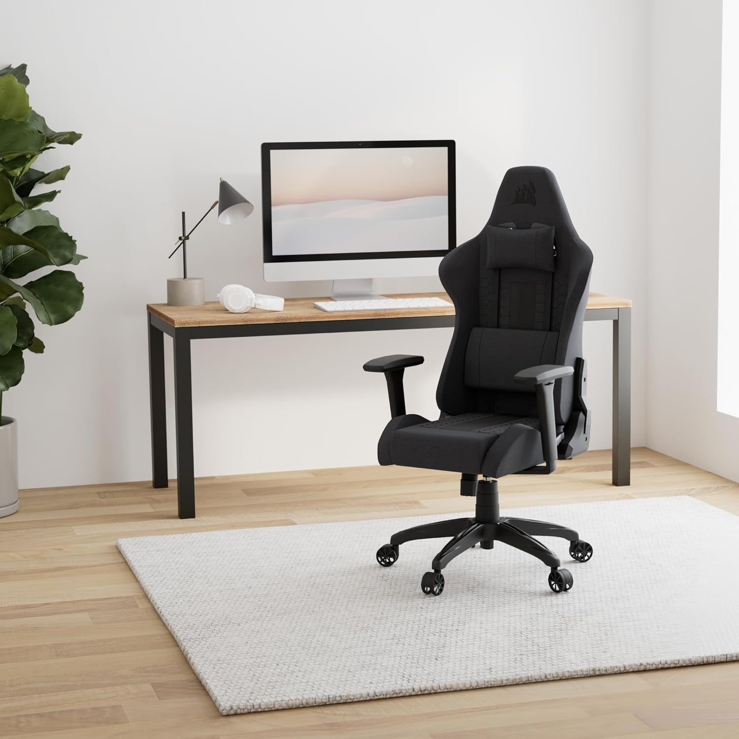 Gray fabric gaming chair in a minimalist home office setting beside a wooden desk.
