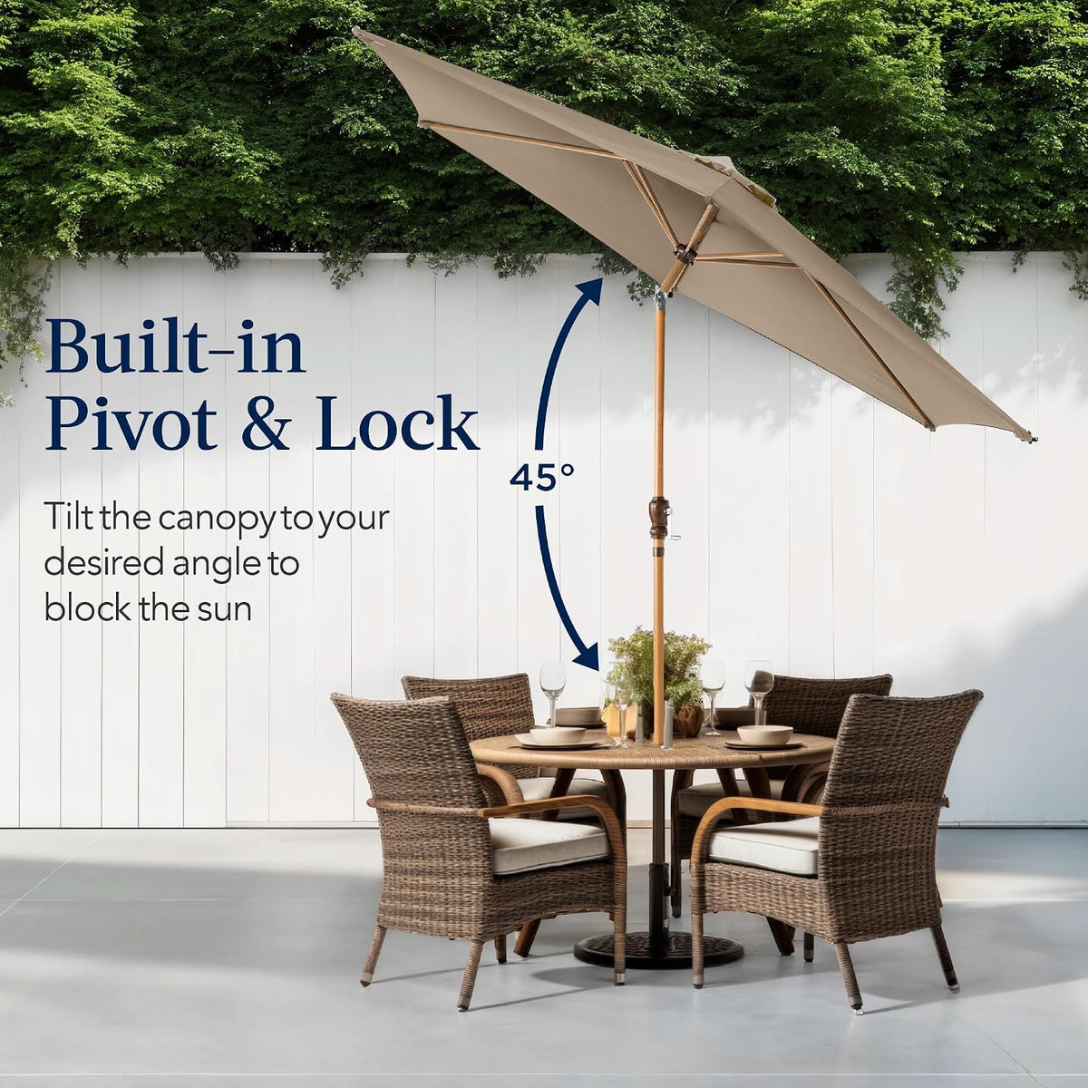 Tan umbrella tilted over an outdoor dining table showing push-button tilt angle and vented top in yard setting.