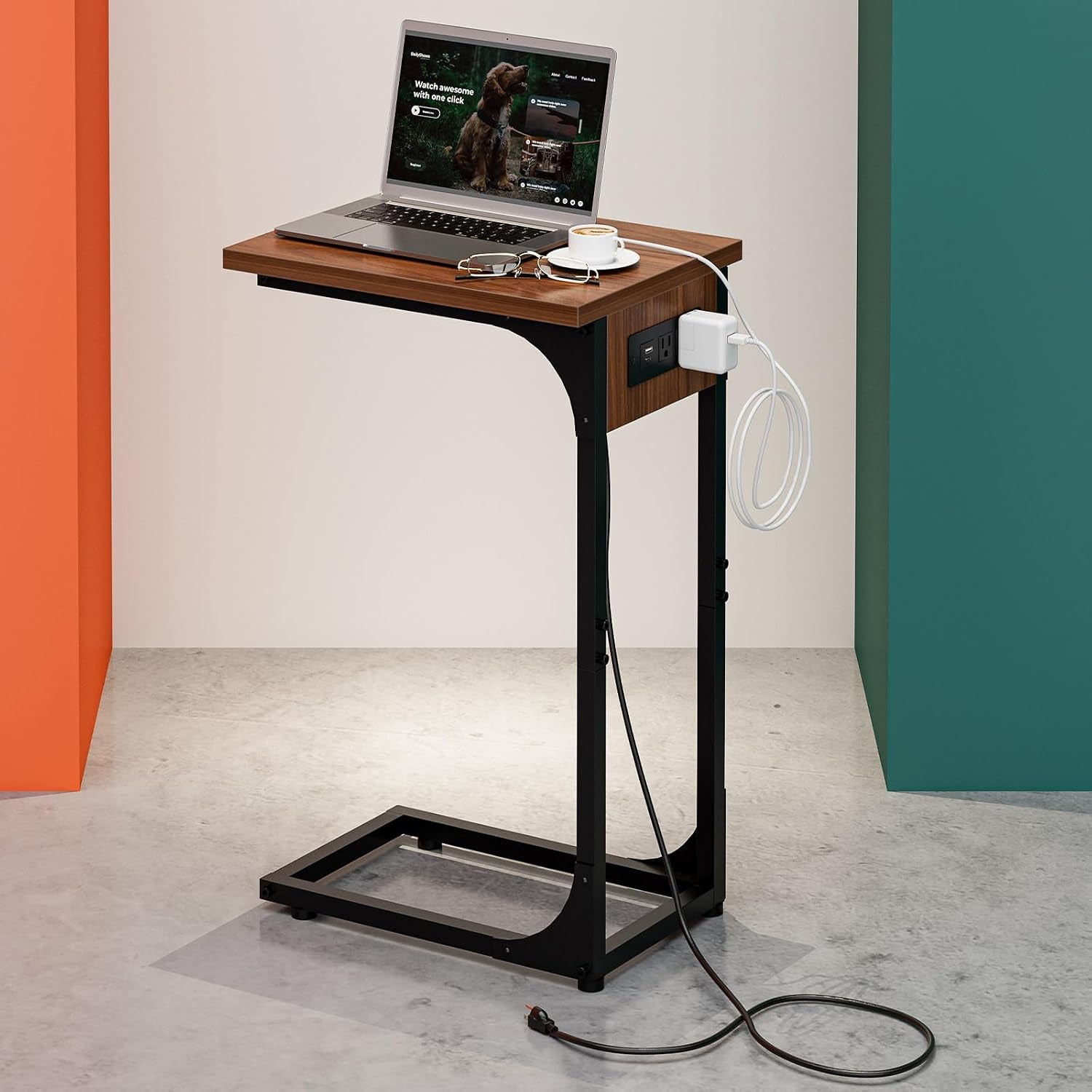 C-shaped end table with walnut top and black steel frame, laptop and charger on top against colored walls.