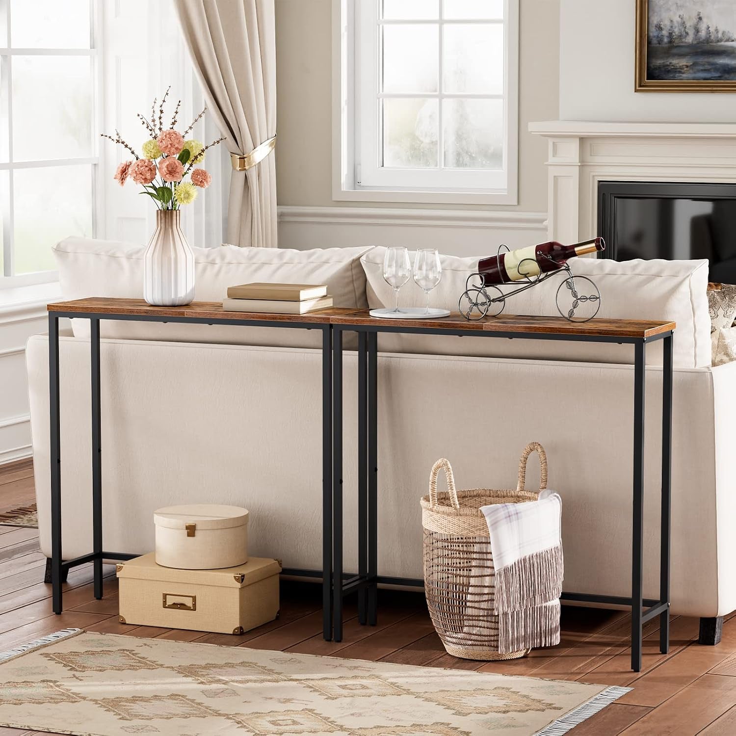 Two narrow console tables side-by-side behind a sofa displaying a vase and a wine bottle holder