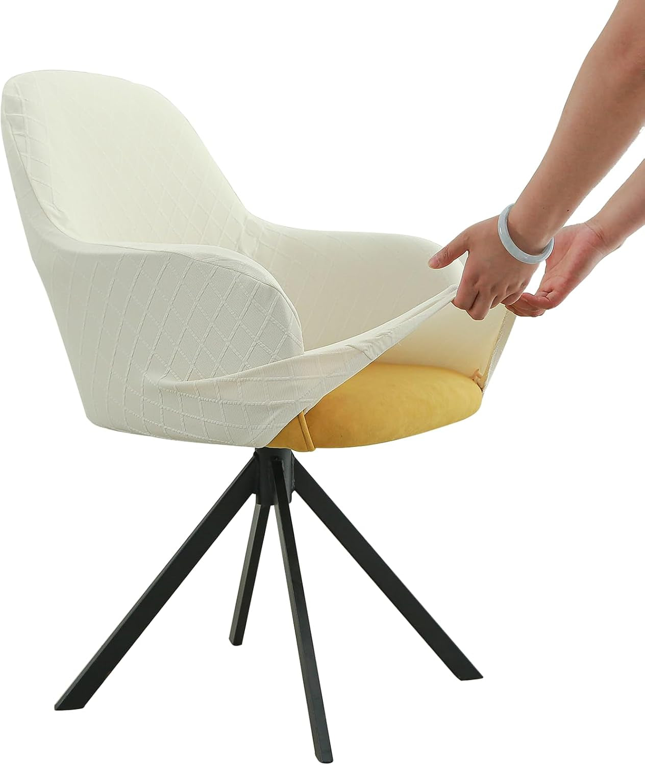 Side view of a cream quilted stretch cover being fitted onto an armchair with hands pulling the fabric.