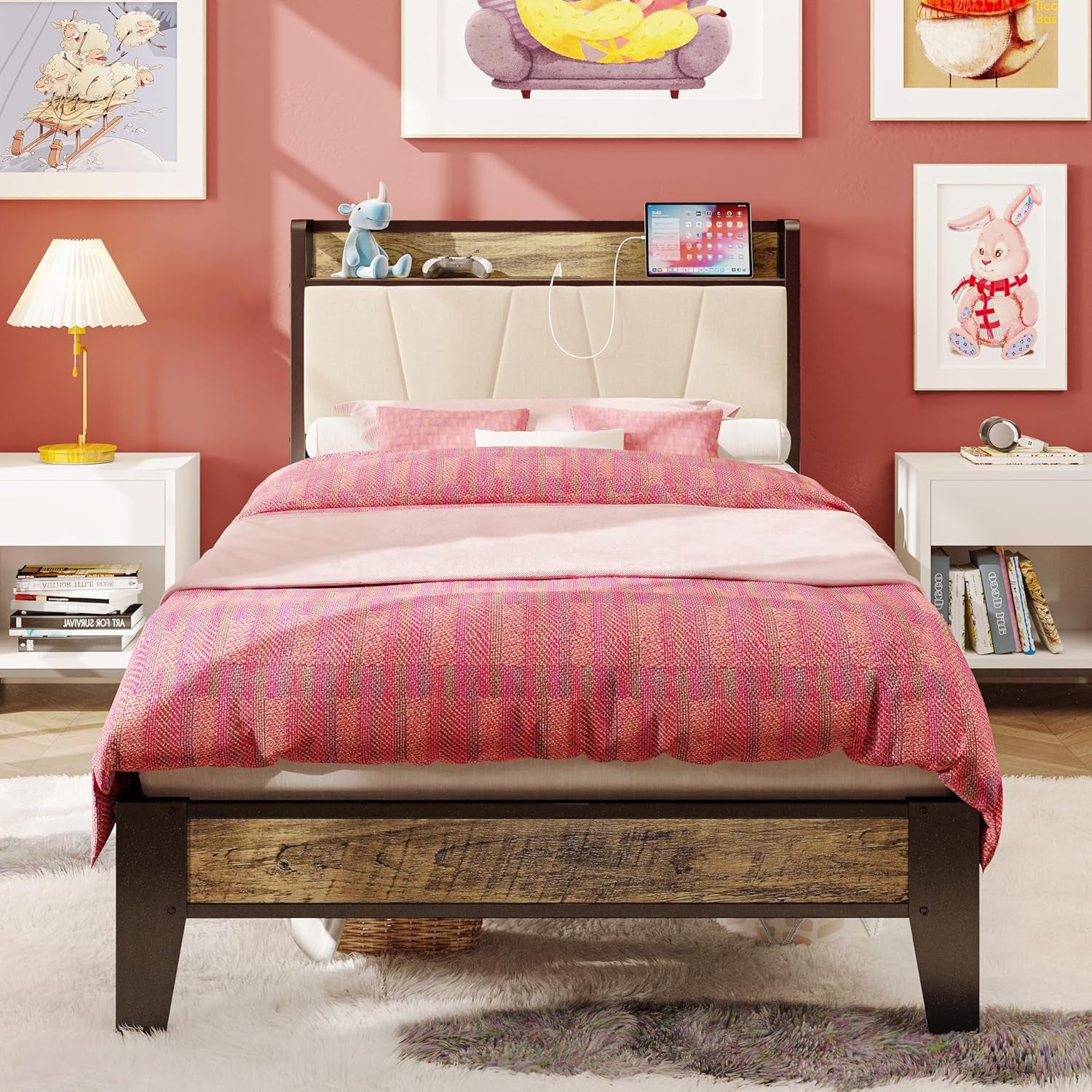 Straight-on shot of the bed in a pink room with a light upholstered headboard panel and a wood-look footboard strip.