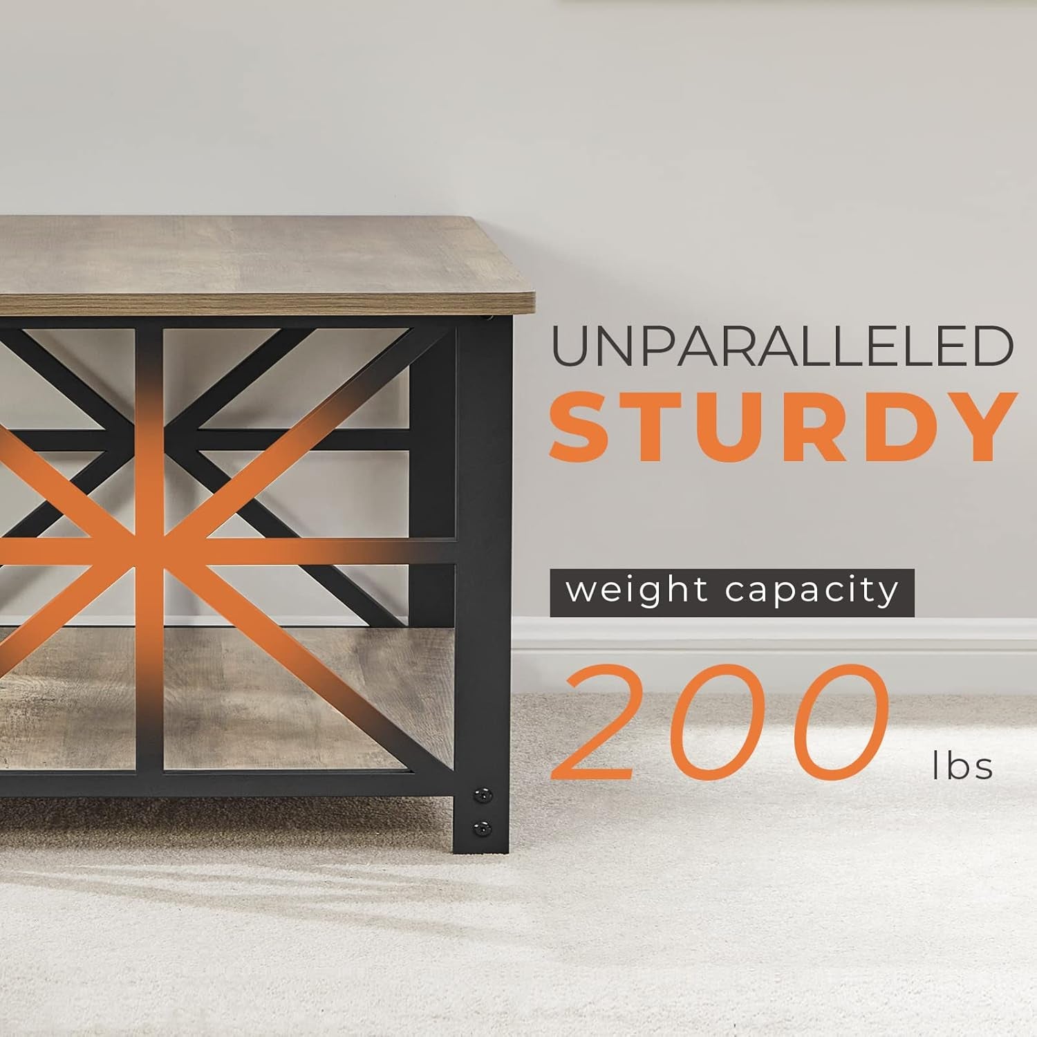 Close-up of one end of a rectangular coffee table showing gray-wash wood top, black metal X-frame and lower shelf on carpet.