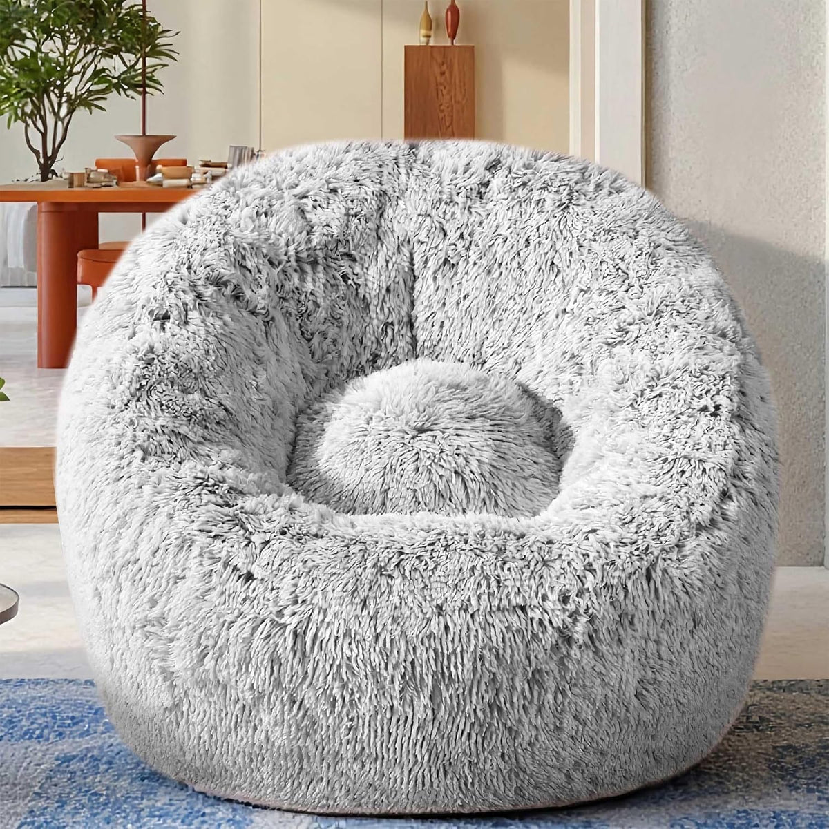 Front view of a round plush light-gray faux fur U-shaped bean bag chair in a living room.