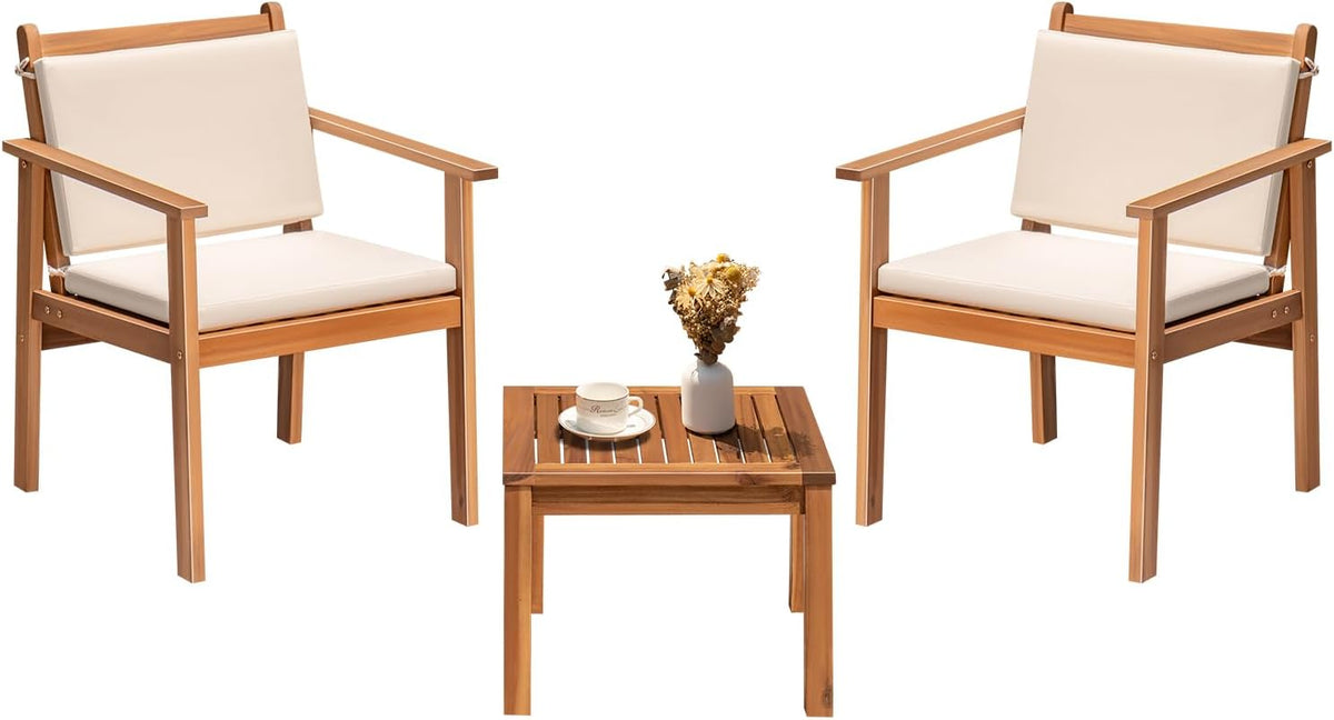 Symmetrical front view of two chairs with cream cushions and a small slatted table holding a cup and dried-flower vase.