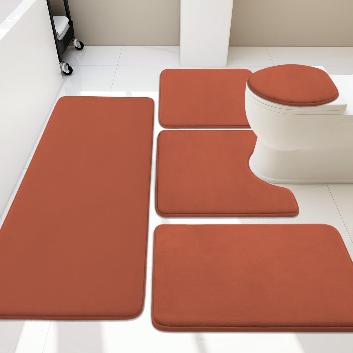 Bathroom layout with a rust-orange five-piece rug set placed around a white toilet and tub.