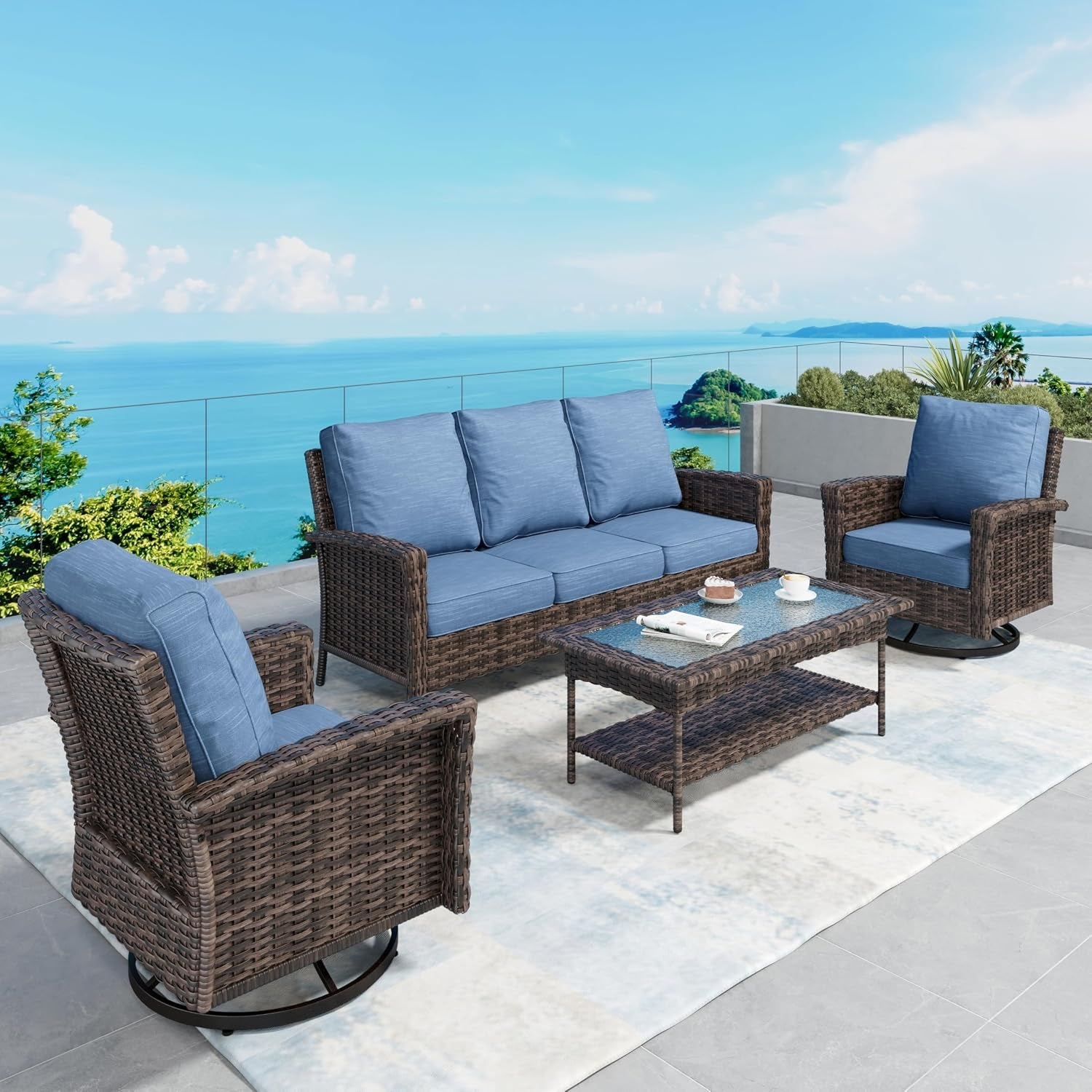 Brown wicker sofa and two swivel chairs with blue cushions arranged around a wicker coffee table on a light rug by the sea.