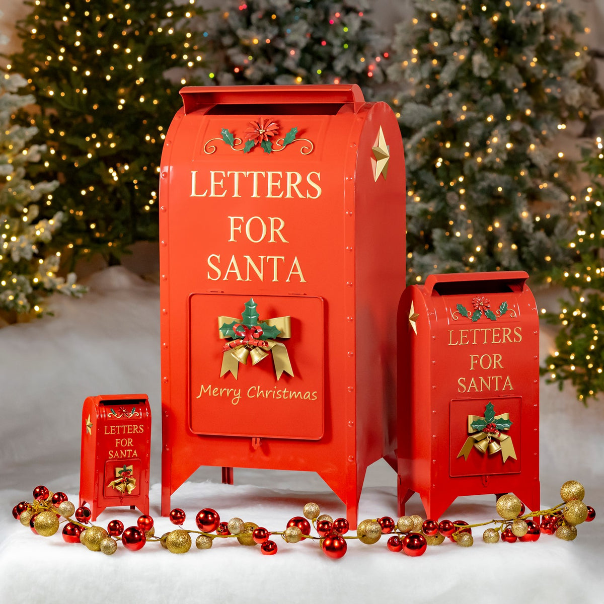 Three red Christmas mailboxes with gold details arranged in snowy holiday decor