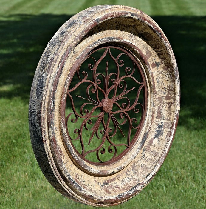 Distressed cream and brown round frame with ironwork, angled view on a lawn