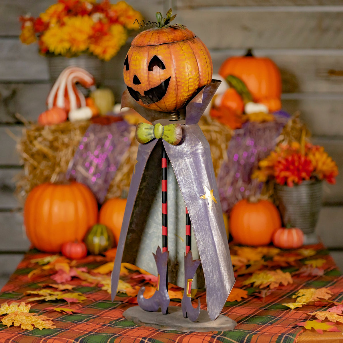 Full pumpkin-headed figurine with a cape on a festive autumn display