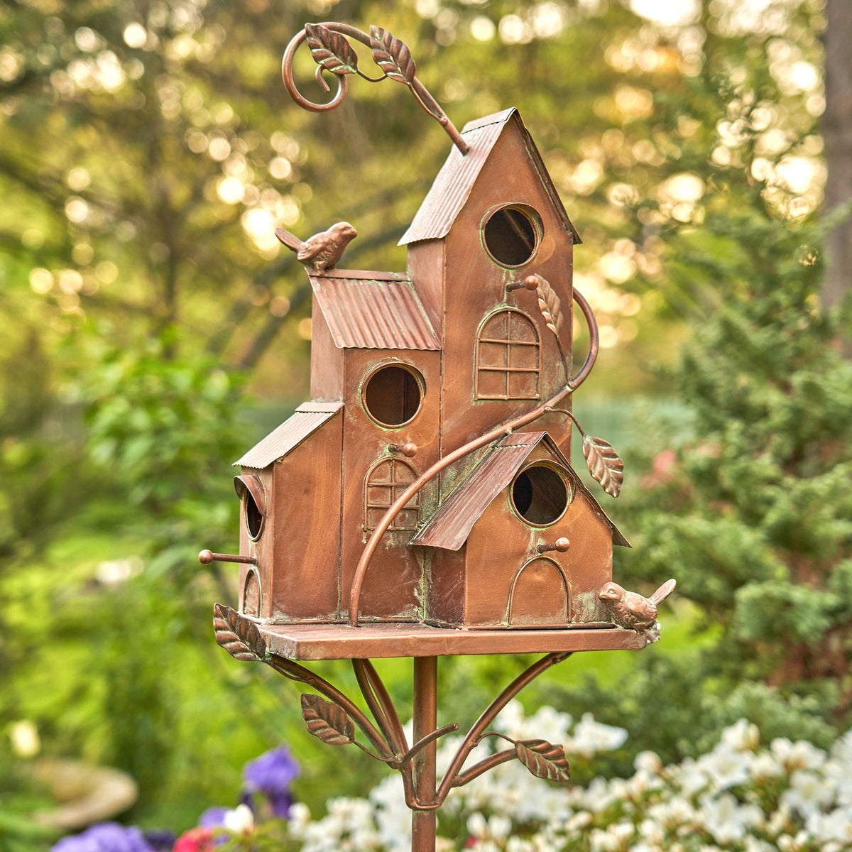 Antique copper bungalow birdhouse stake with multiple entry holes, front view in a garden
