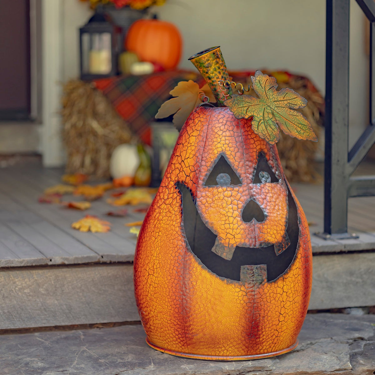 Orange crackle-finish jack-o'-lantern standing on a porch in a front view