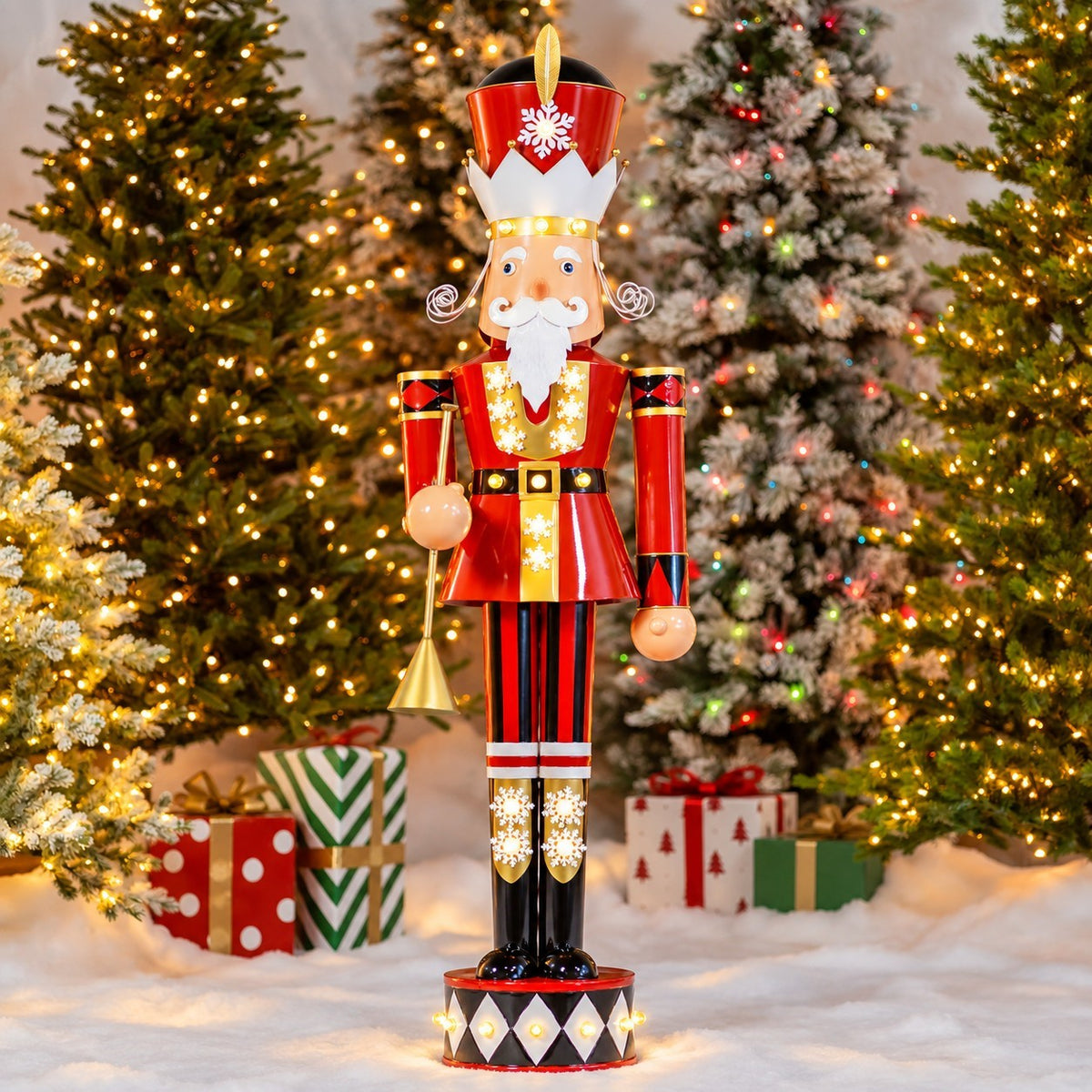 Red-and-gold nutcracker holding a trumpet, standing before decorated Christmas trees and wrapped gifts.