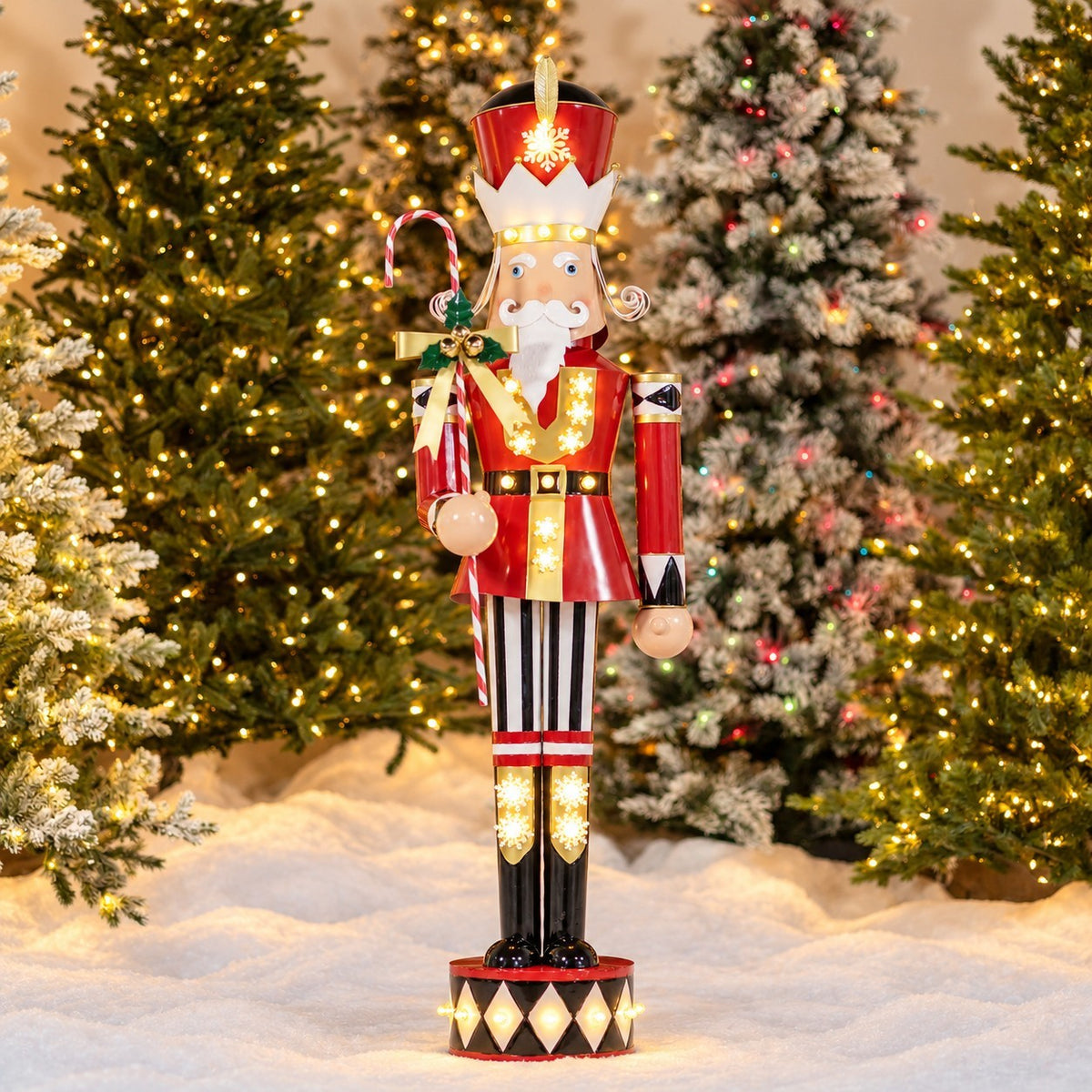 Full nutcracker figure holding a candy cane staff, standing among lit Christmas trees.