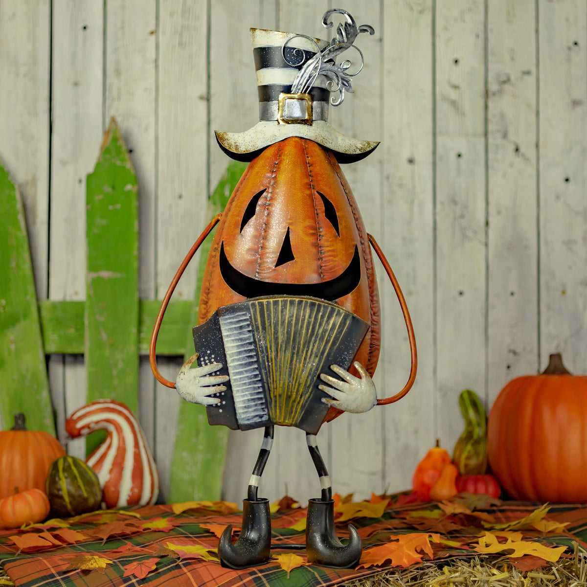 Orange Jack-O'-Lantern figurine wearing a hat and holding an accordion, full view outdoors