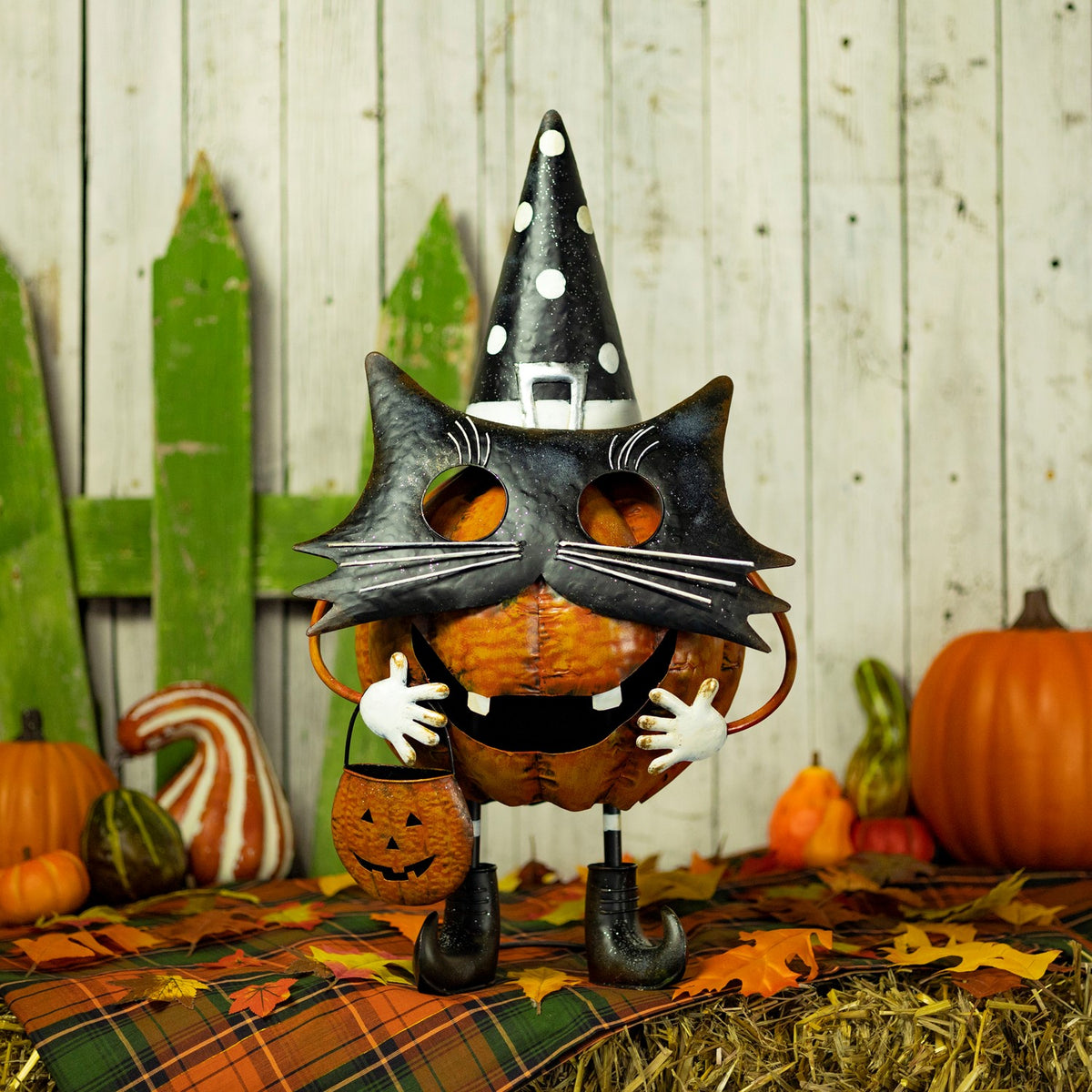 Full orange-and-black pumpkin cat figurine standing in an autumn Halloween display