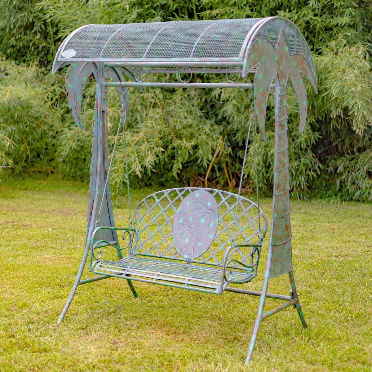 Verdi green iron palm-tree swing bench standing on a lawn, front view