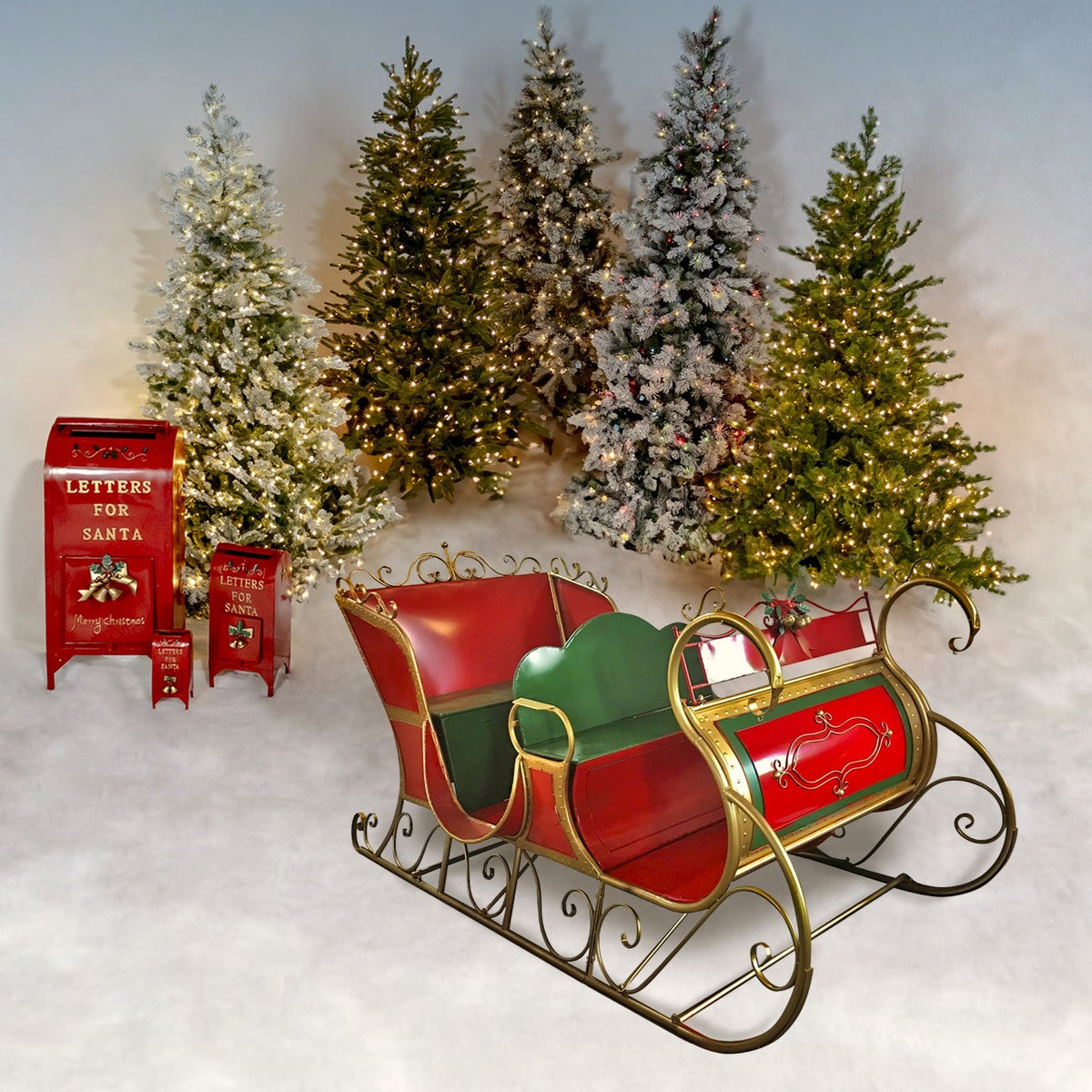 Red and green ornate sleigh displayed before several lit Christmas trees