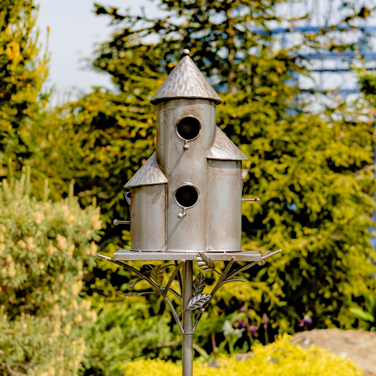 Silver-tone triple birdhouse stake viewed from the front in a garden