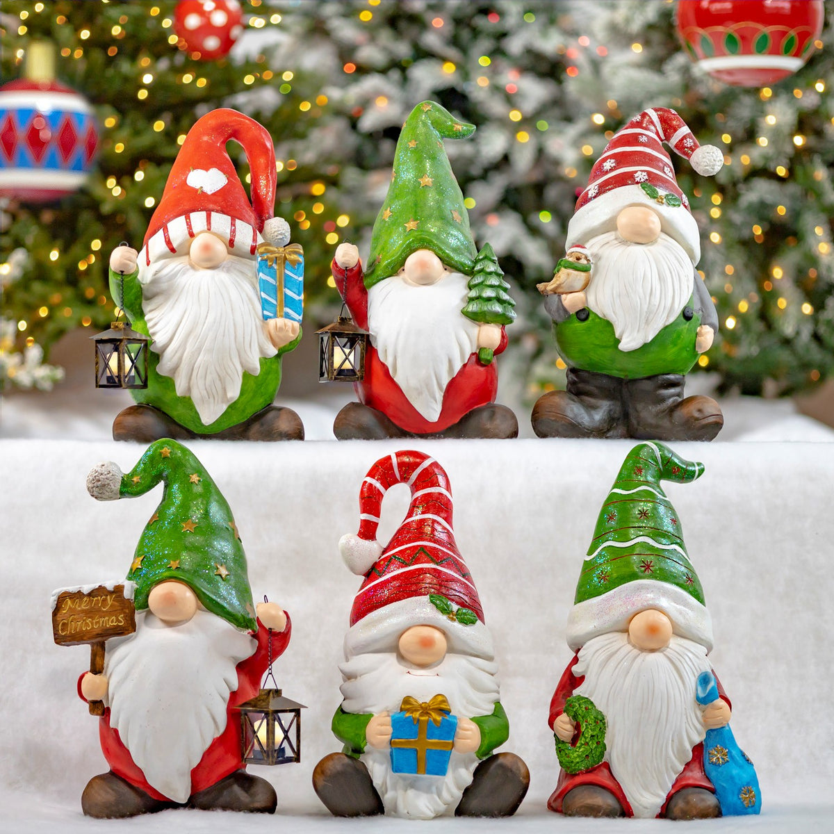 Six colorful Christmas gnome statues arranged together before a decorated tree