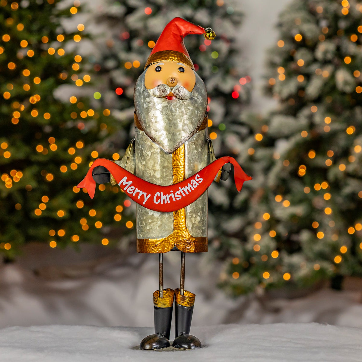 Full Santa figurine with red sash standing before a lit Christmas tree