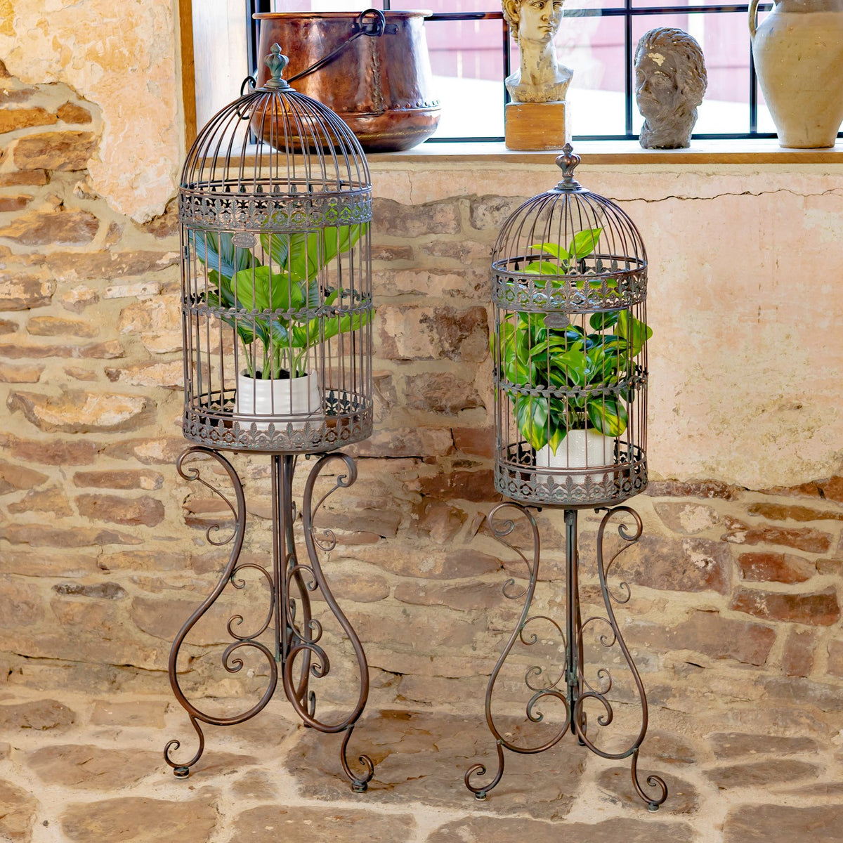 Antique bronze birdcage decorations with plants on freestanding stands