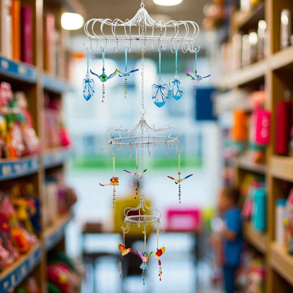 White tiered hanging display with colorful ornaments suspended in a shop aisle
