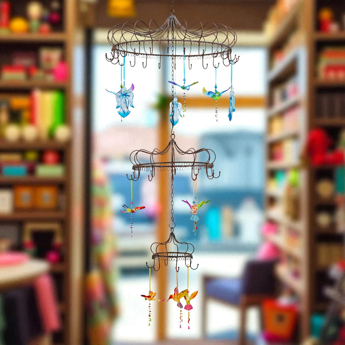 Three-tier iron hanging display with colorful ornaments in a shop setting
