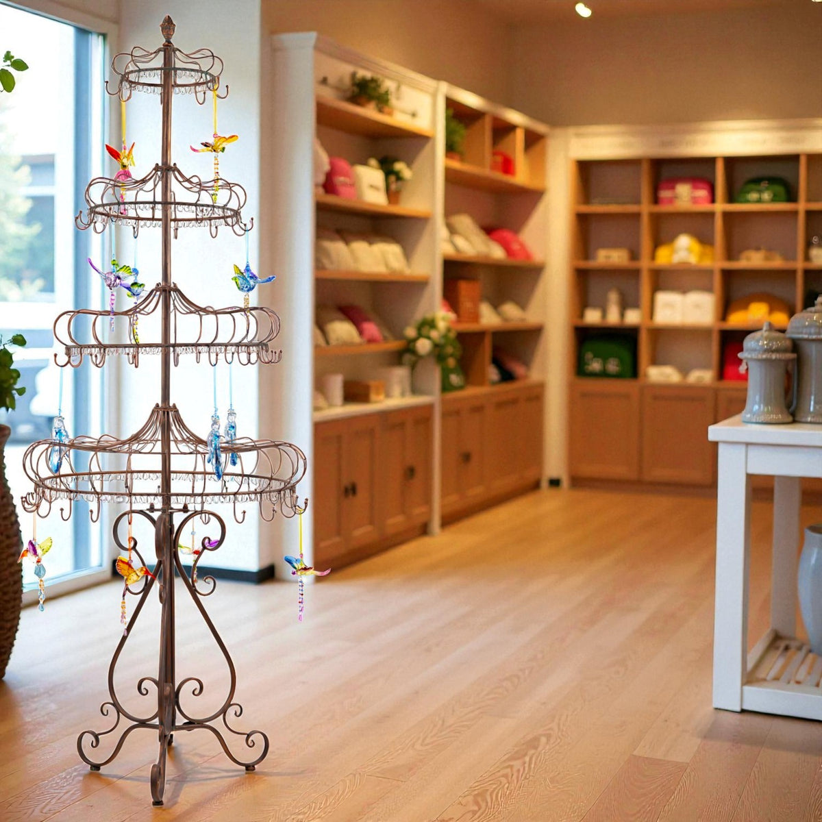 Antique-bronze tiered metal display stand with hanging ornaments in a bright shop interior.