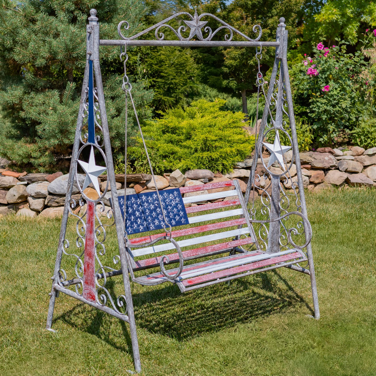 Distressed iron American flag swing bench shown at an angle on a lawn