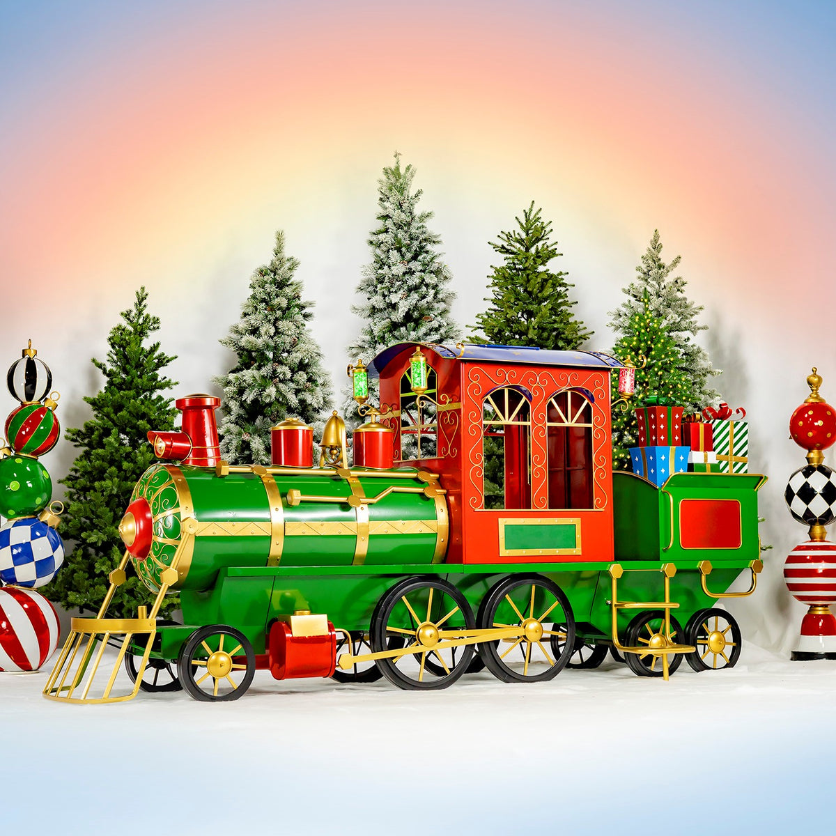 Green, red and gold Christmas train with cart in a snowy holiday display