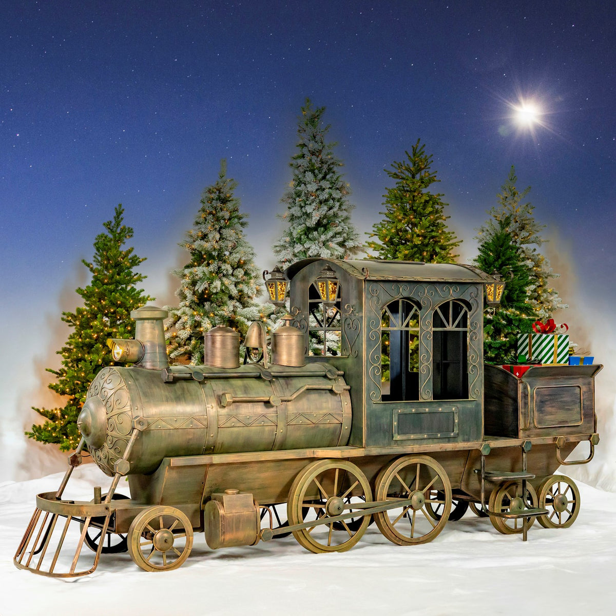 Antique bronze iron train display in snow with decorated trees at night