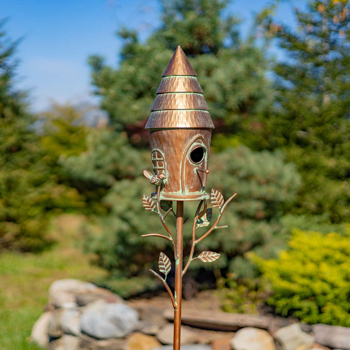 Antique copper birdhouse stake shown upright in a garden close view