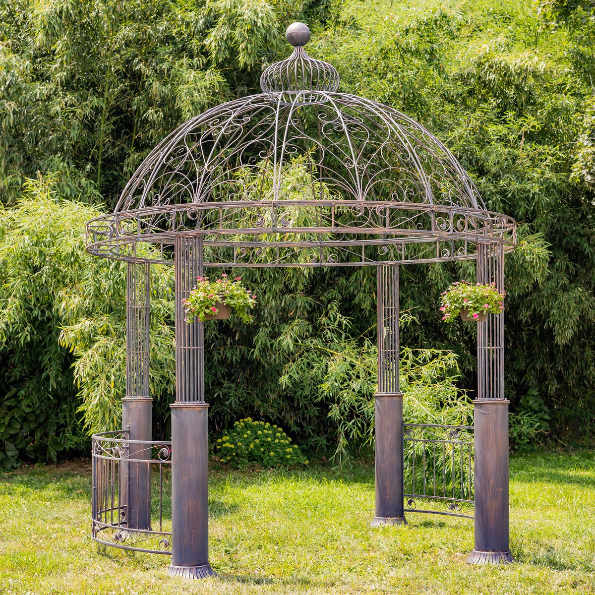 Dark bronze round gazebo with a domed iron roof and hanging flower baskets on its posts.