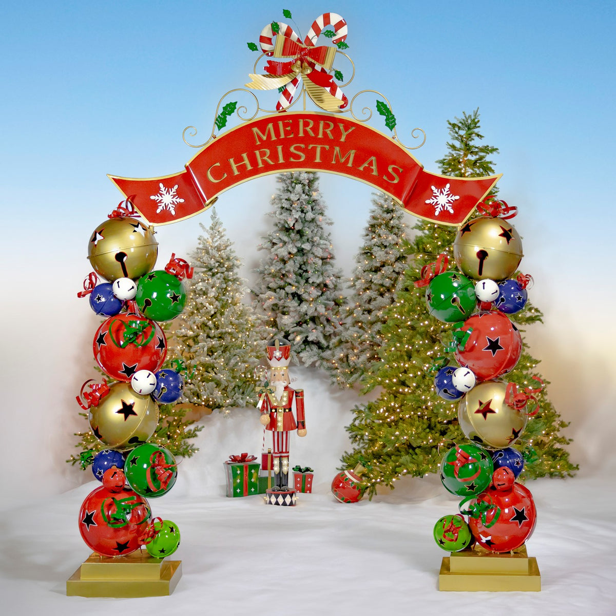 Full Christmas archway with colorful bell pillars in a snowy tree setting