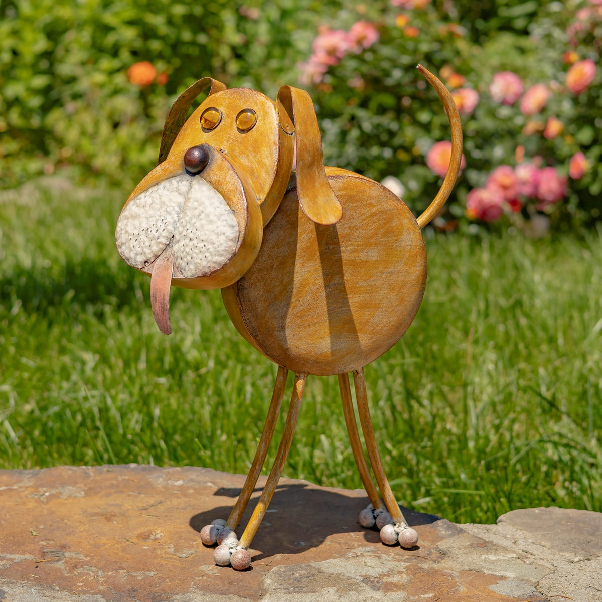 Full view of a rust-gold iron dog planter standing on a garden stone path