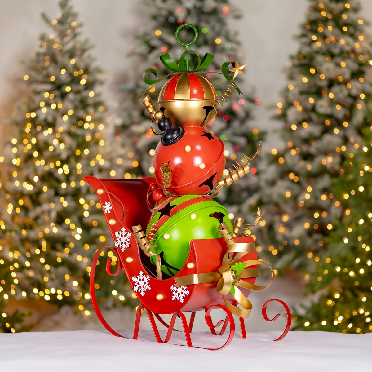 Red and green holiday figures ride in a red sleigh decorated with snowflakes, ribbons and bells.