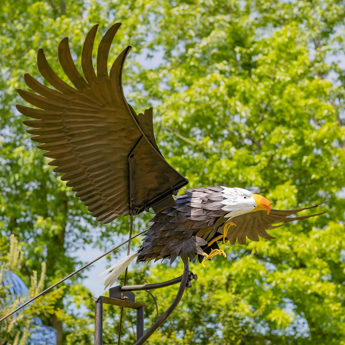 Iron bald eagle garden stake with raised wings, viewed close up outdoors