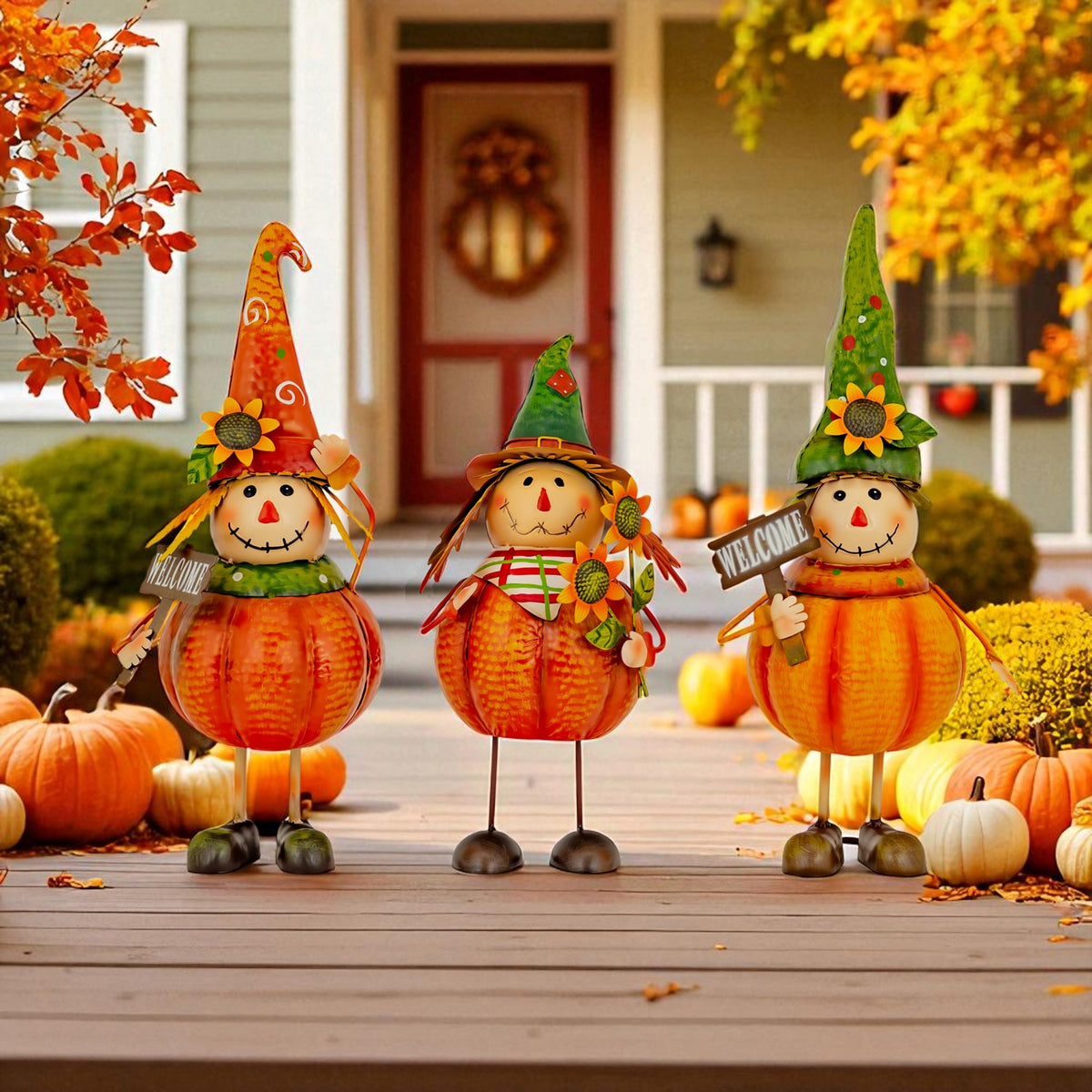 Three pumpkin scarecrow figurines stand on a porch among autumn leaves and pumpkins.
