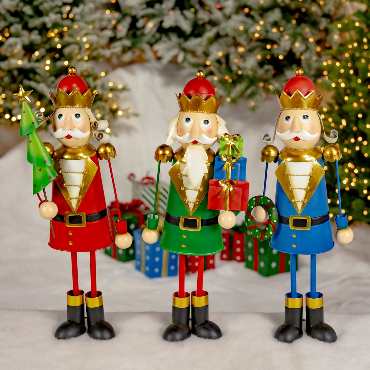 Three colorful nutcracker figures stand beneath a decorated Christmas tree with wrapped presents.