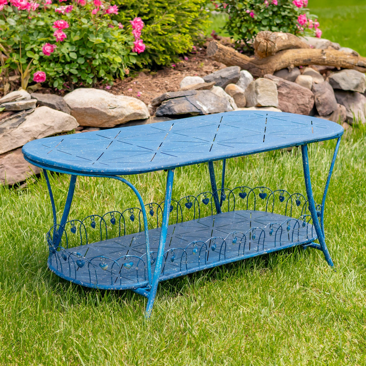 Antique blue oval garden table with lower shelf, angled view on grass