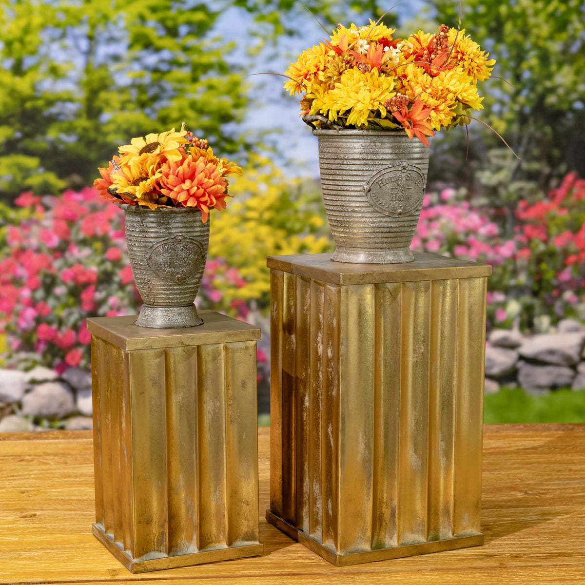 Pair of gold-toned fluted pillars topped with flower pots, shown from a slightly different angle.