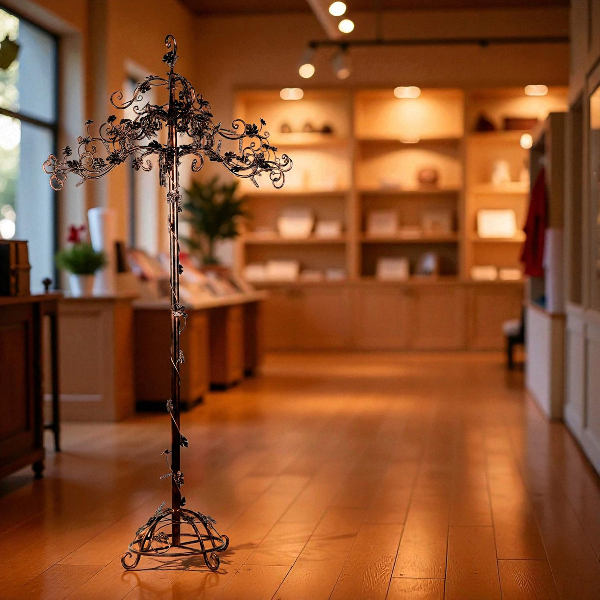 A dark bronze iron display tree with curling branches stands in a shop interior.