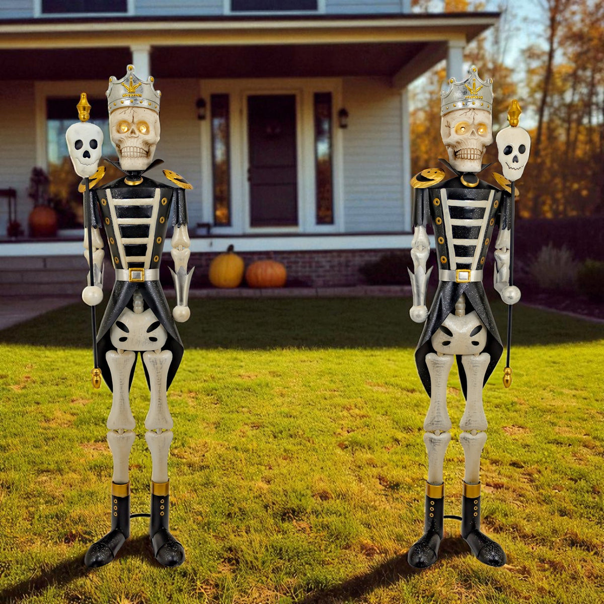 Pair of black and gold skeleton sentries standing on a lawn outside a house