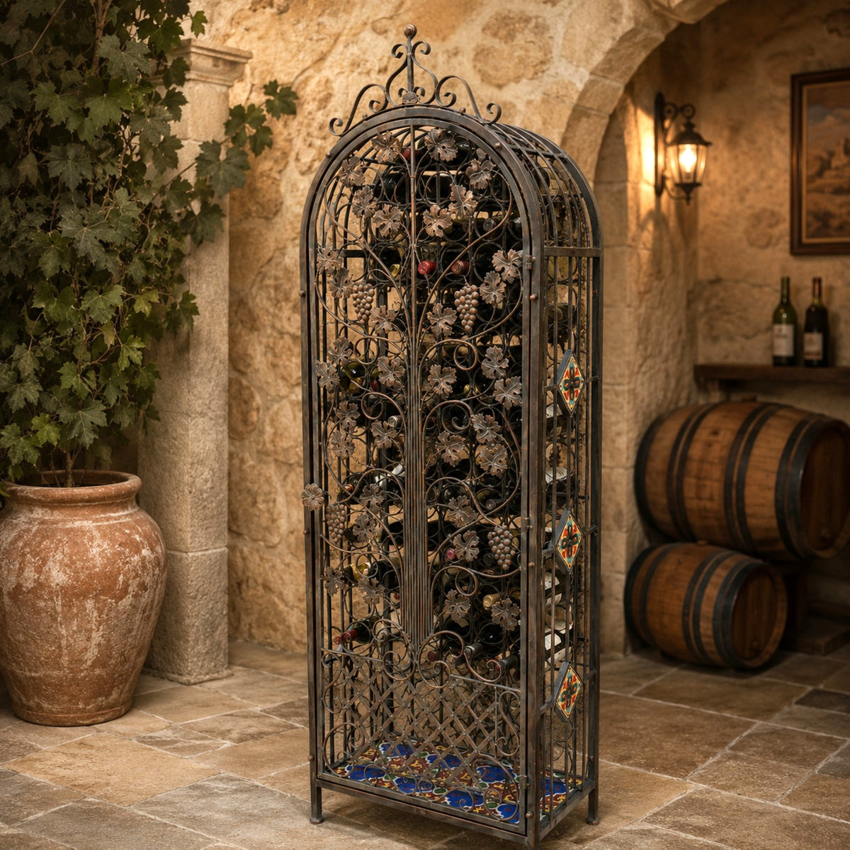 Ornate arched iron wine cabinet filled with bottles in a rustic stone cellar.