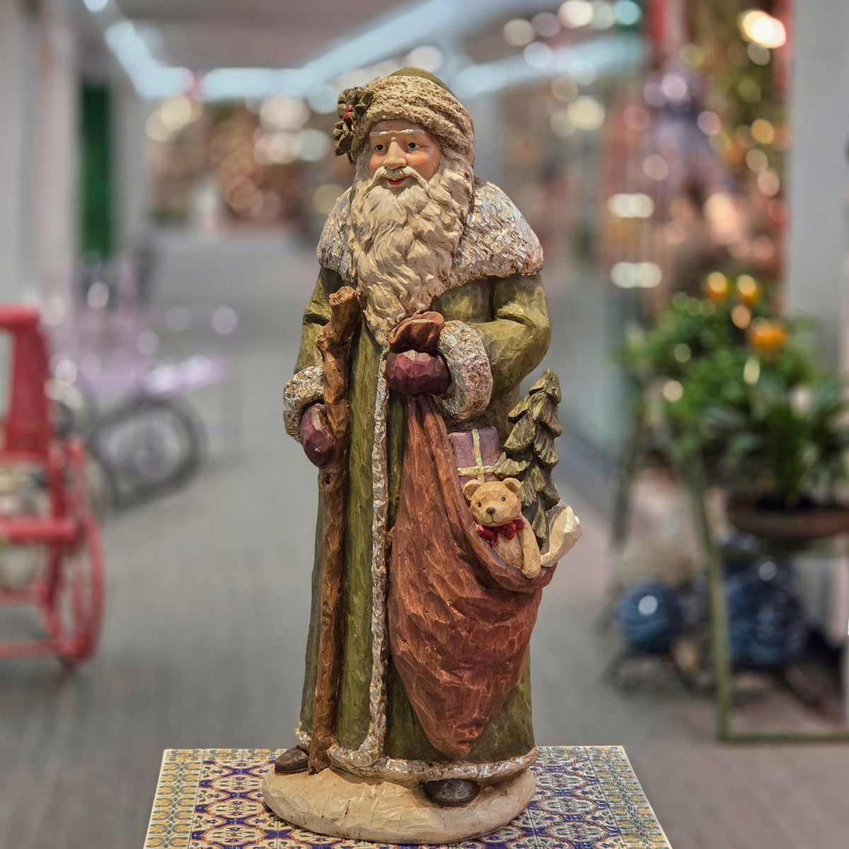 Full Woodland Santa figurine with staff and gift sack standing in a showroom