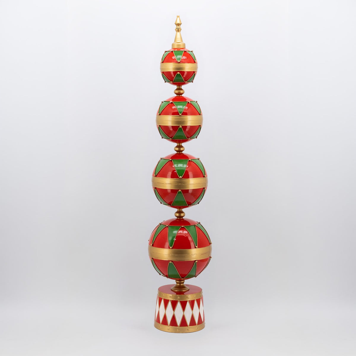 A tall decorative tower of four red and green patterned spheres with gold bands and a matching base.