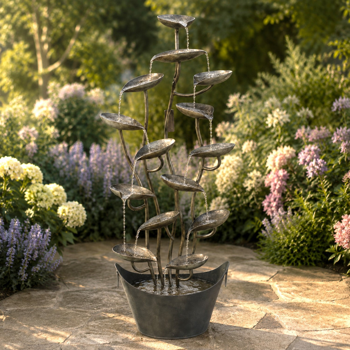 Sculptural metal fountain with cascading leaf-shaped bowls standing in a sunlit garden.