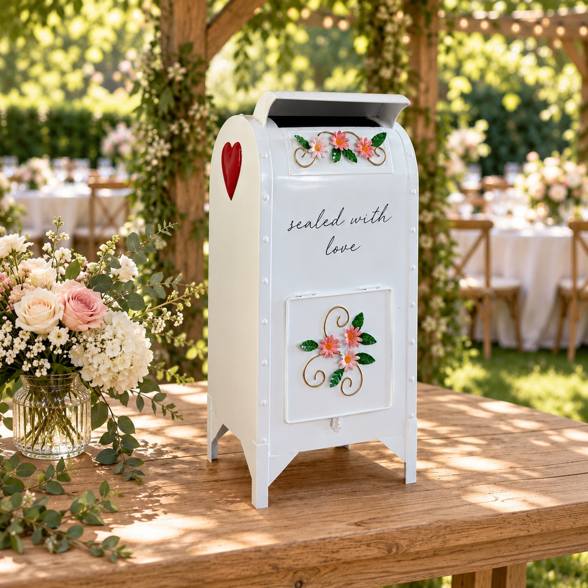 Glossy white wedding card mailbox on a wooden table in a garden