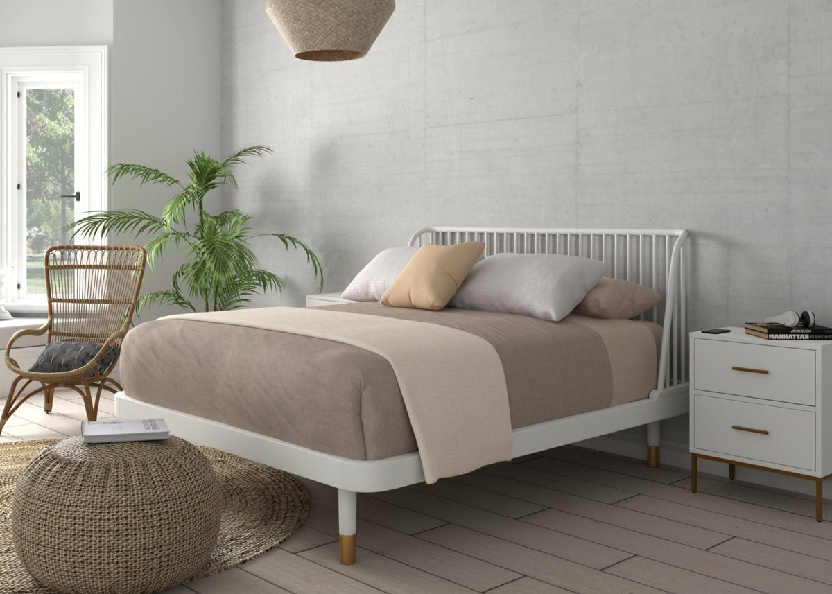 White slat-back platform bed shown in a bright bedroom, angled side view